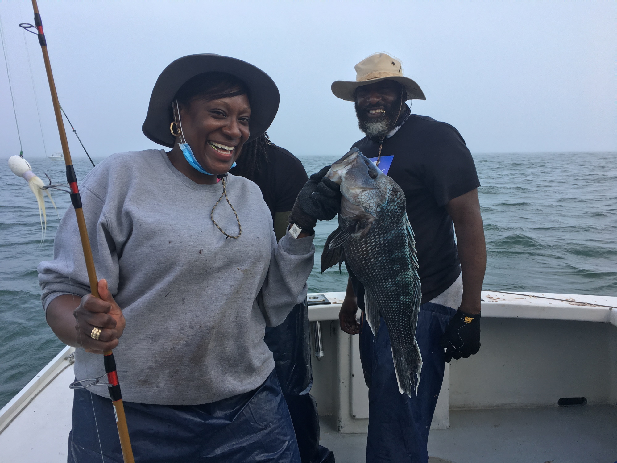 woman holding up a sea bass